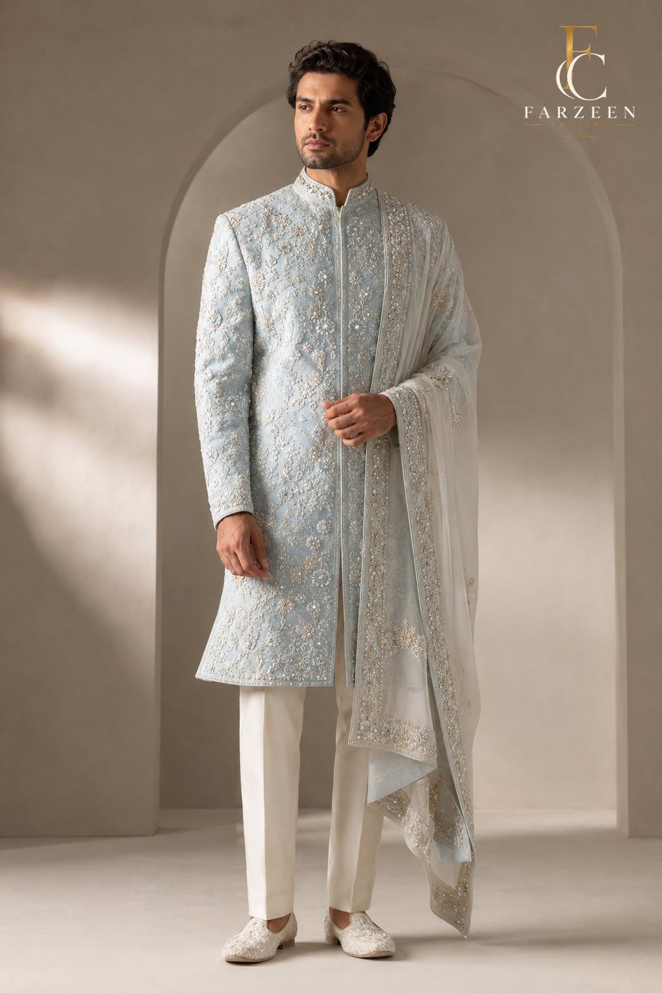 Groom in an ice-blue silk sherwani with silver floral embroidery and stole