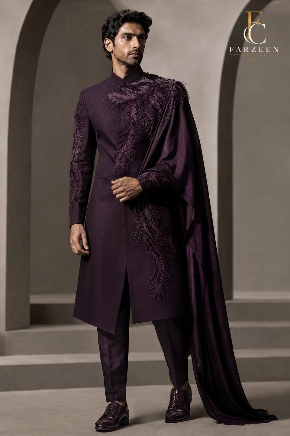 Man in an aubergine sherwani with a flowing satin cape
